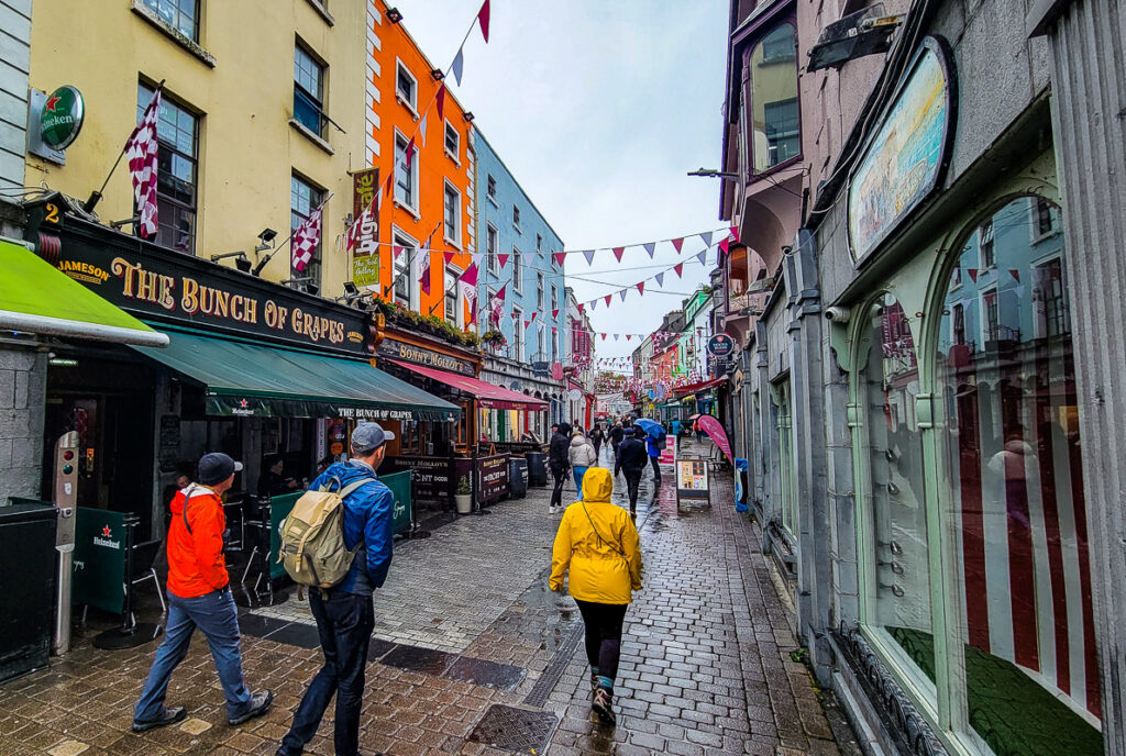 People walking down a city street surrounded by shops