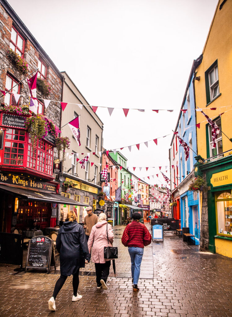 People walking down a city street surrounded by shops