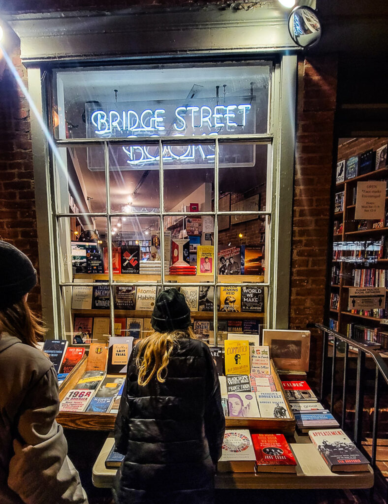 Two girls looking in the window of a bookstore