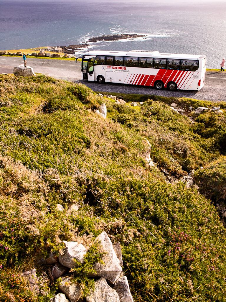 Tour bus on the road with ocean in background