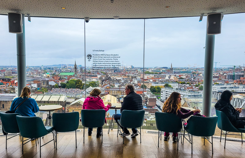 People sitting at tables overlooking a city skyline