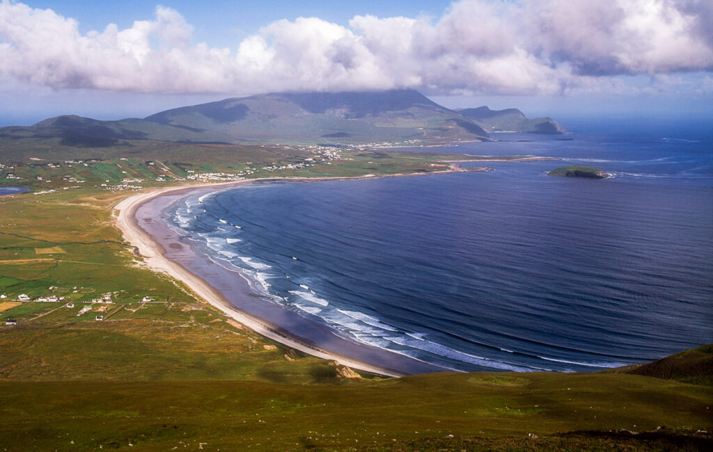 Aerial view of a beach with golden sand and dark blue water