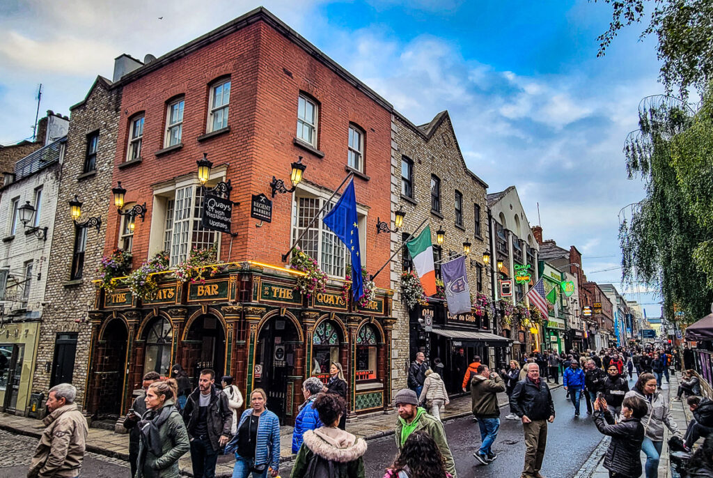 Row of pubs and people walking down the street