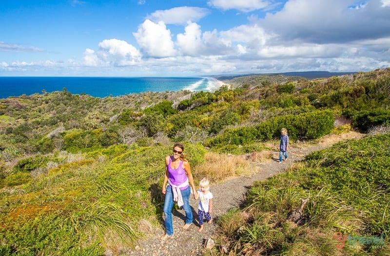 people walking on grassy dunes