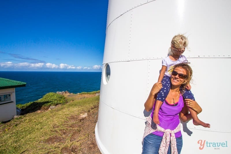 people standing next to a lighthouse