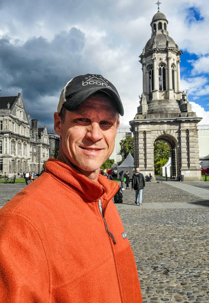 Man standing in front of a bell tower