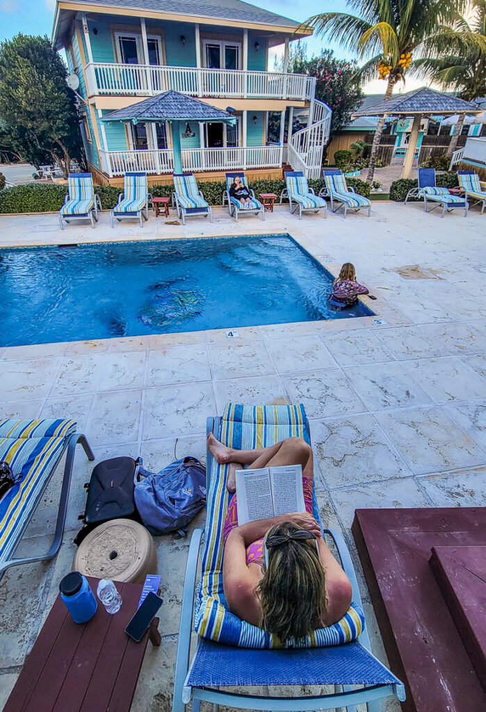 Lady reading a book by a pool