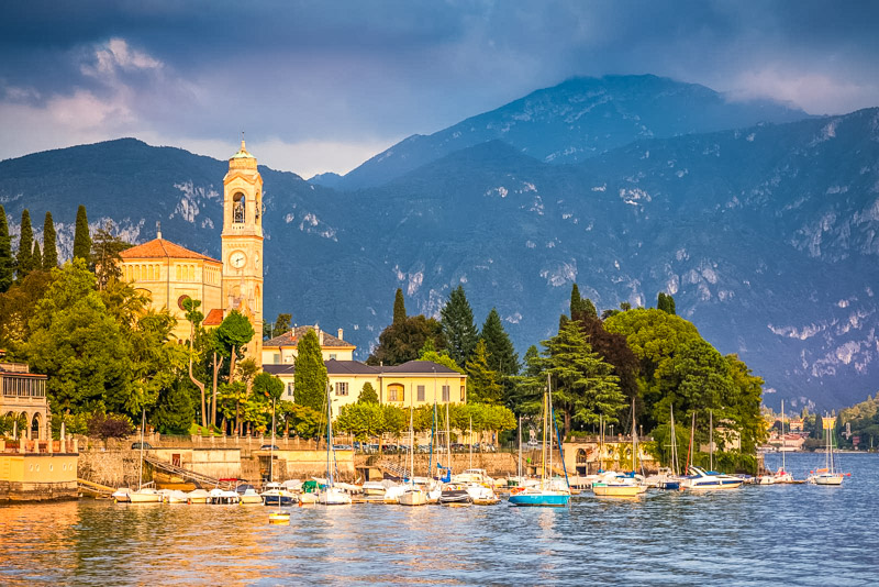 Idyllic Lake Como coastline with Tremezzo village and sailboats at sunny day