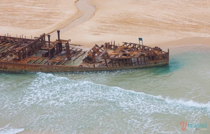 aerial of rusted shipwreck on sand