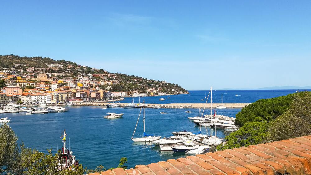 boats in the water and homes on the mountain 