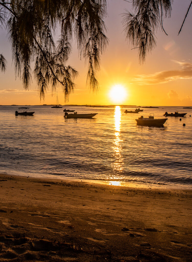 Sunset over the ocean with boats on the water