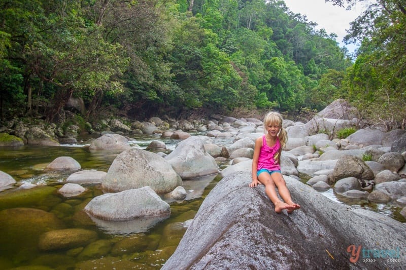 girl sitting on boulder by the river in Mossman Gorge