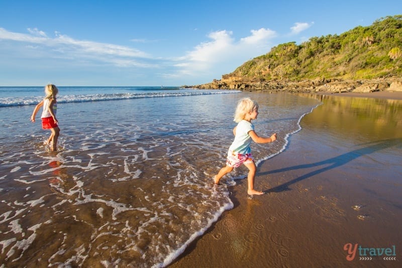 kids running through the water on the beach