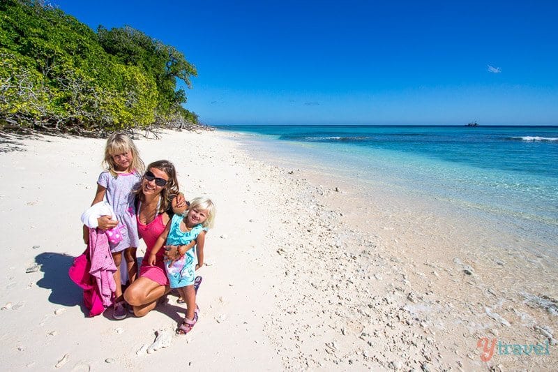 family and two daughters posing on the beach on Lady Musgrave Island, 