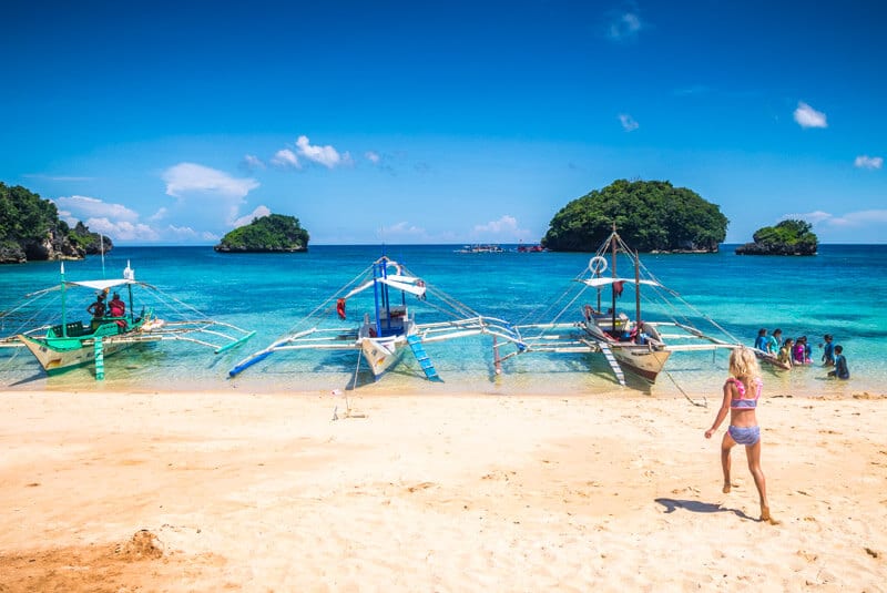 girl running towards boats on shore at Ilig Iligan Beach Boracay 