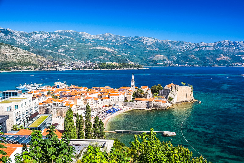 orange colored roofed buildings in old town budva on the water