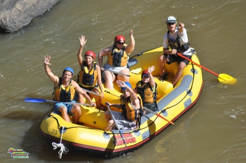 peopel in raft waving to camera 