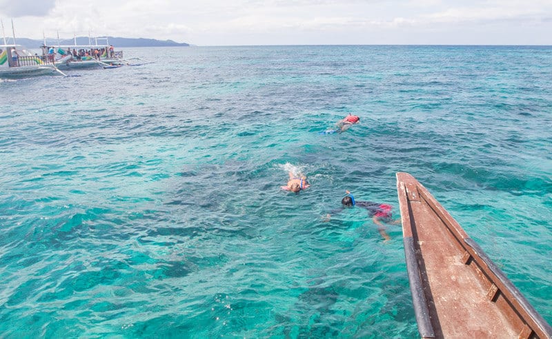 people snorkeling next to a boat