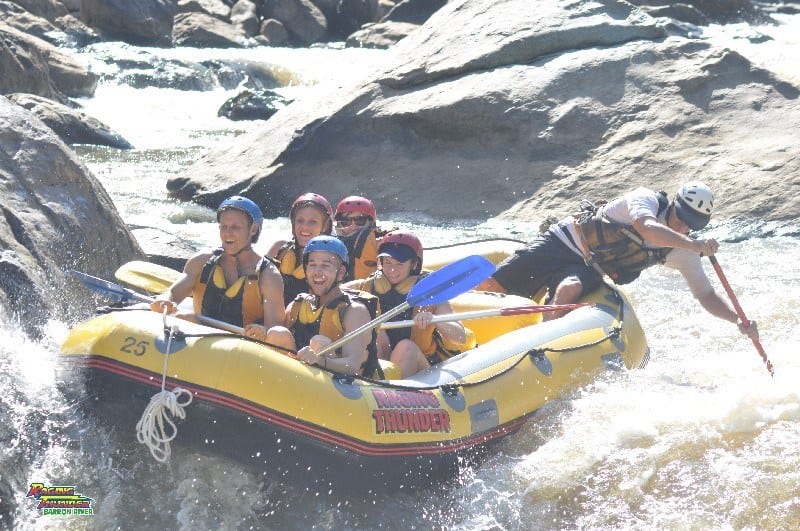 people bumping rocks on white water rafting ride