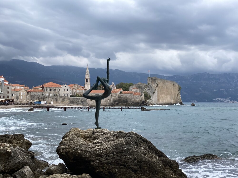 statue of ballerina on rock