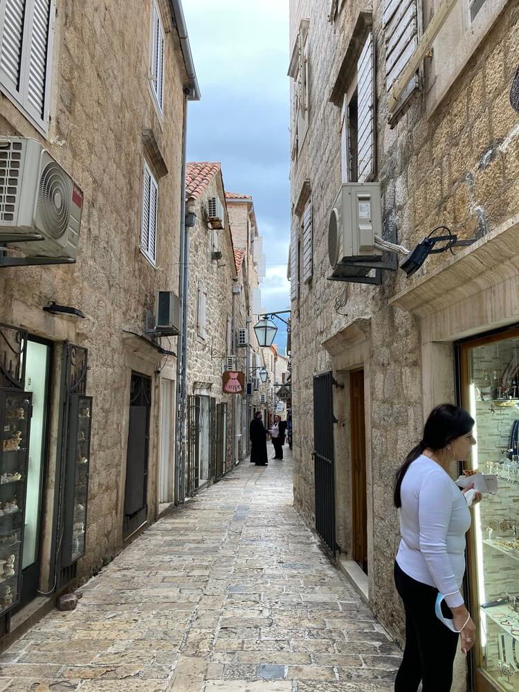 people walking down alleyways looking at shop windows.