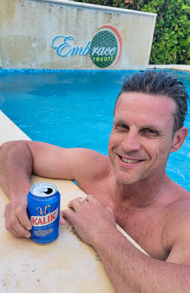 Man drinking a beer by the pool