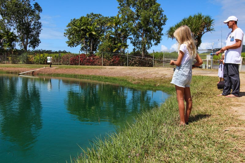 girl and man fishing in pond