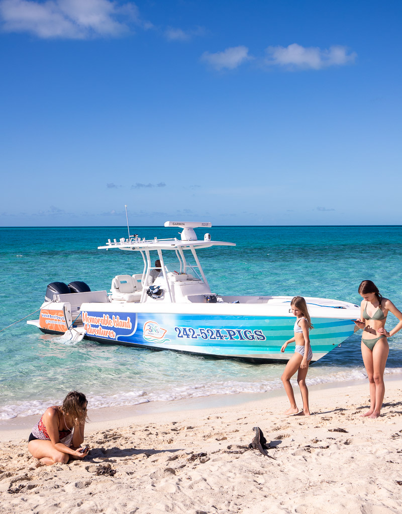 Mom and two daughters on a beach with a boat in the background