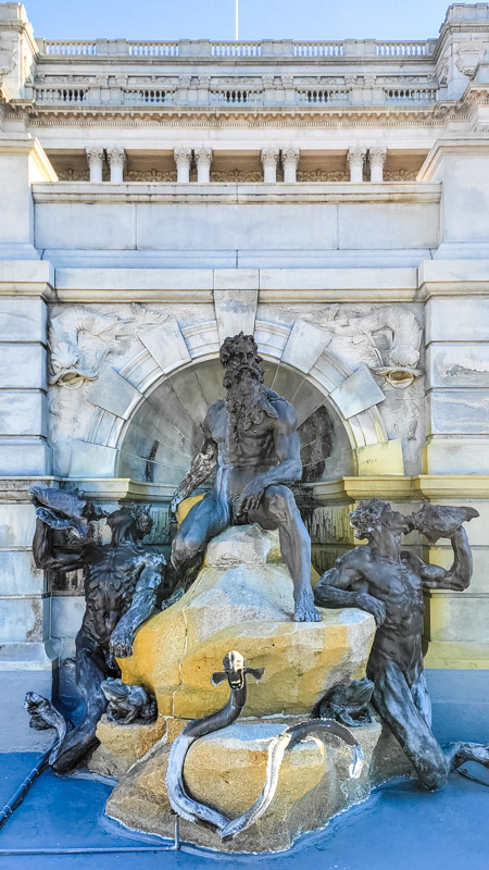 neptune and sea nymph sculptures in front of pond