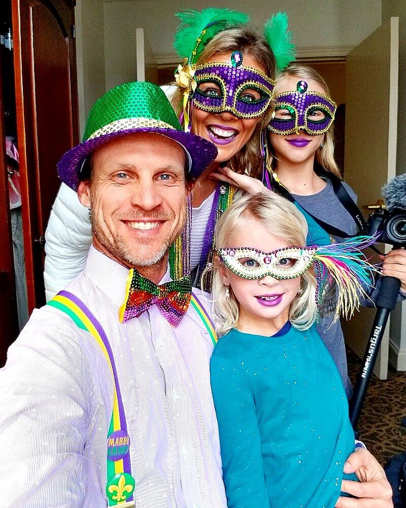 family posing in purple masks and Mardi Gras Costumes