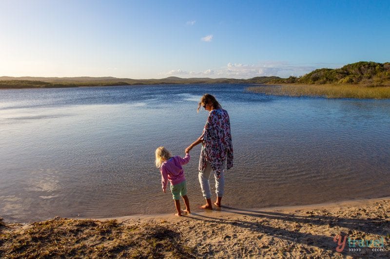 woman and girls holding hands at the edge of Blue Lagoon, Moreton Island, 