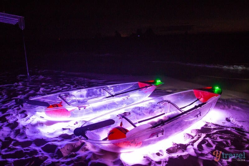 Transparent kayaks lit up at night