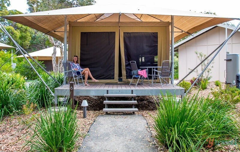 woman sitting on porch of glamping tent