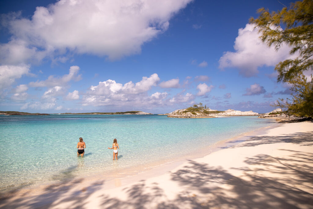 Mom and daughter wading in water at a beach