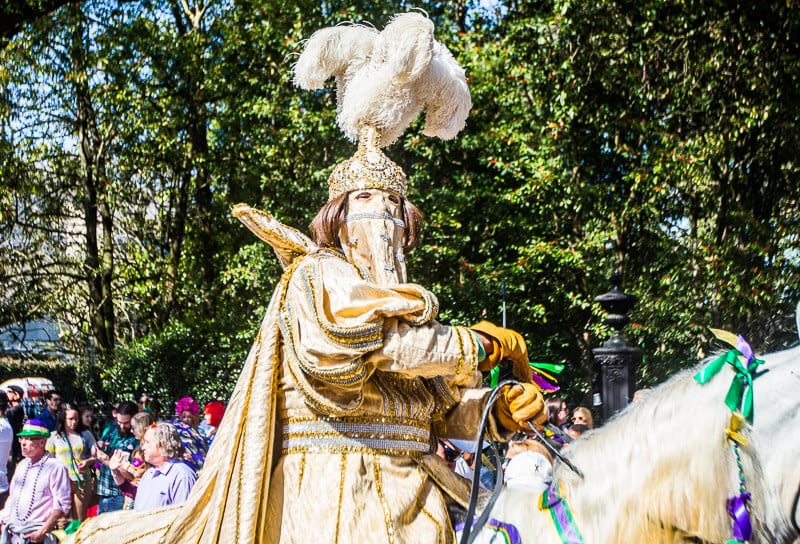 man in gold costume on horse in parade