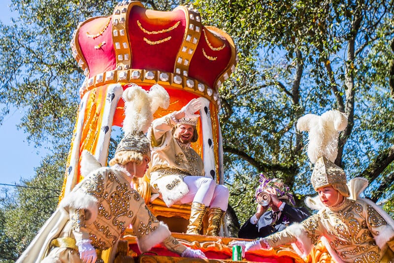 King Rex waving on float  at the Rex Parade during Mardi Gras colors.