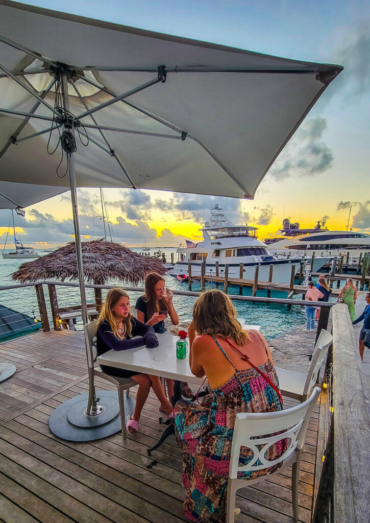 Mom and daughters sitting on a deck over water watching sunset