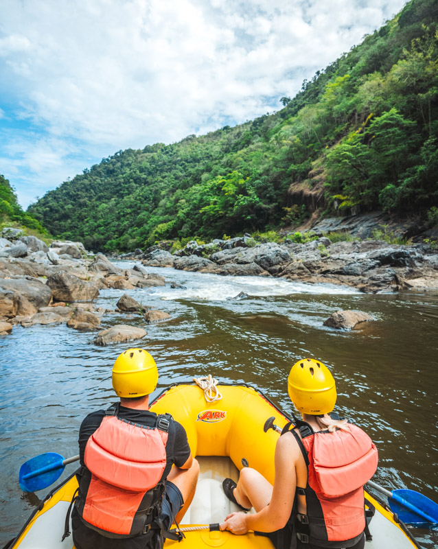 Couple sitting in the raft, paddling down the Barron River