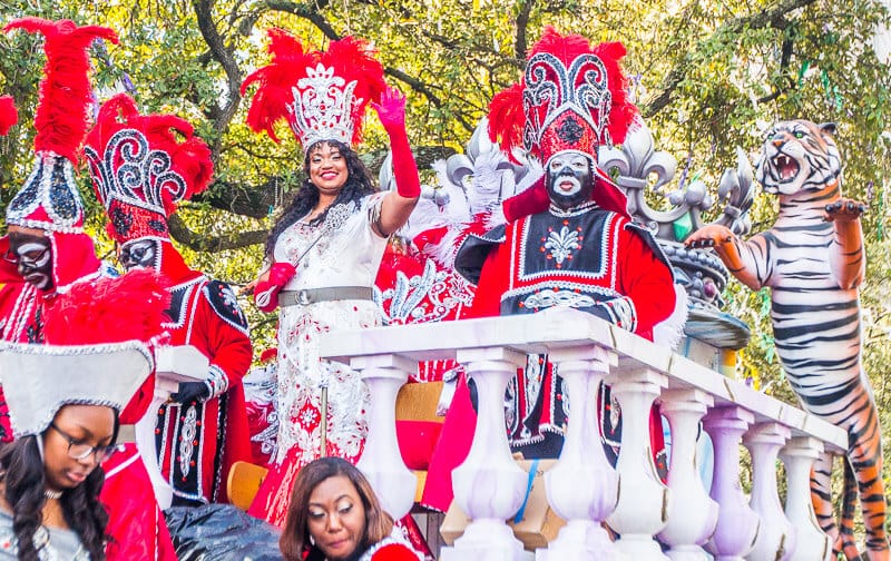 wom and costumed men waving to crowds on Zulu float