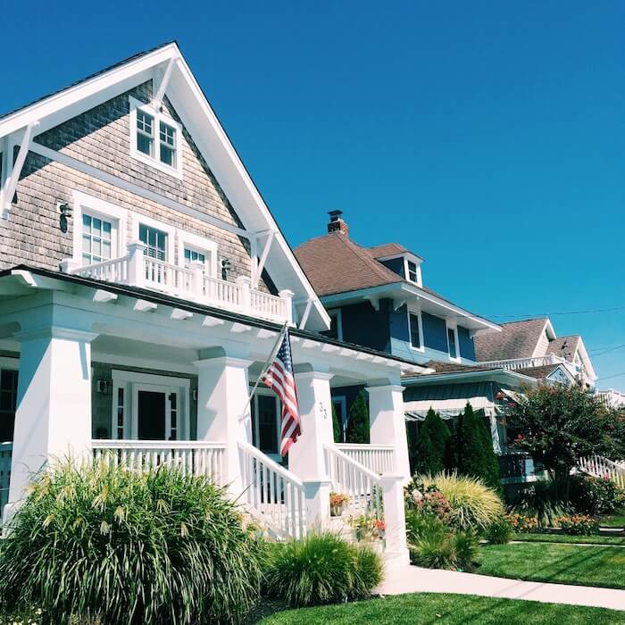 home with us flag out front and green grass in Avalon