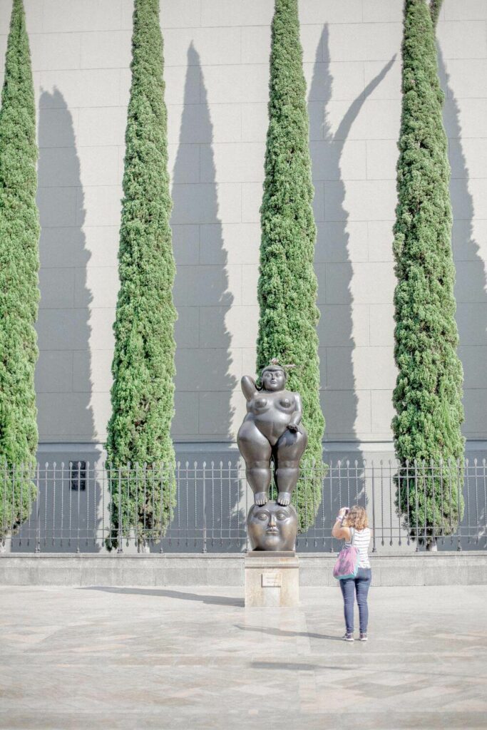 person photographing sculpture in Botero Plaza
