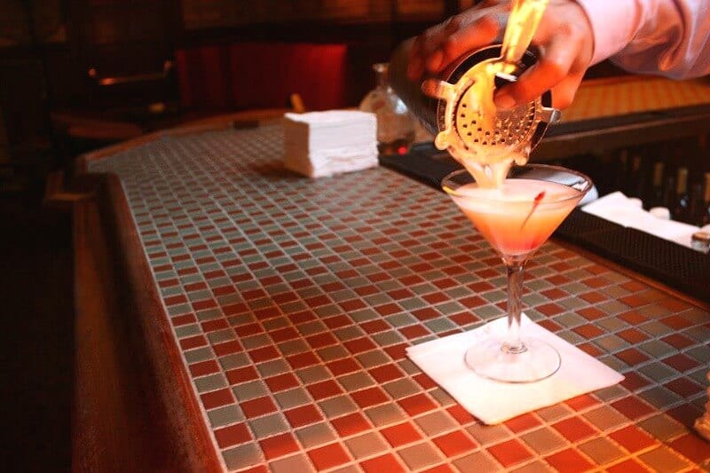 person pouring cocktail at the bar Campbell Apartment