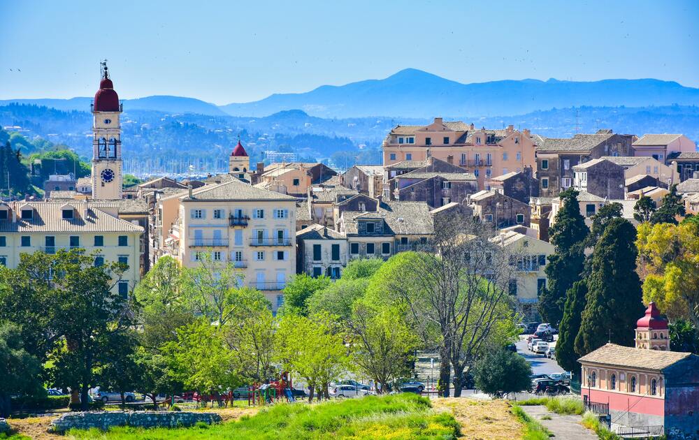 buildings in village witho mountains in the background Corfu greece