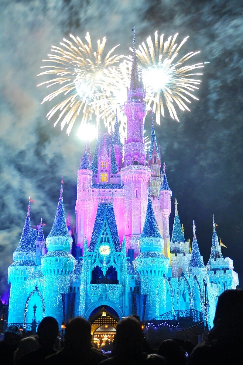 disney castle with fireworks in the sky