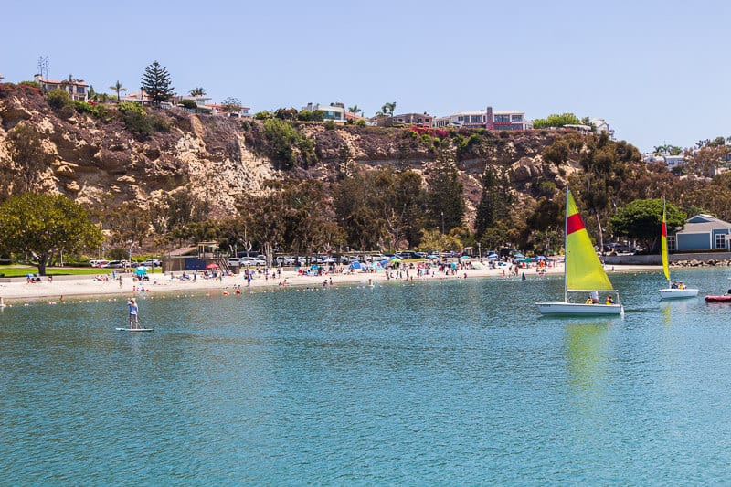 Sailing boats and a beach under a headland