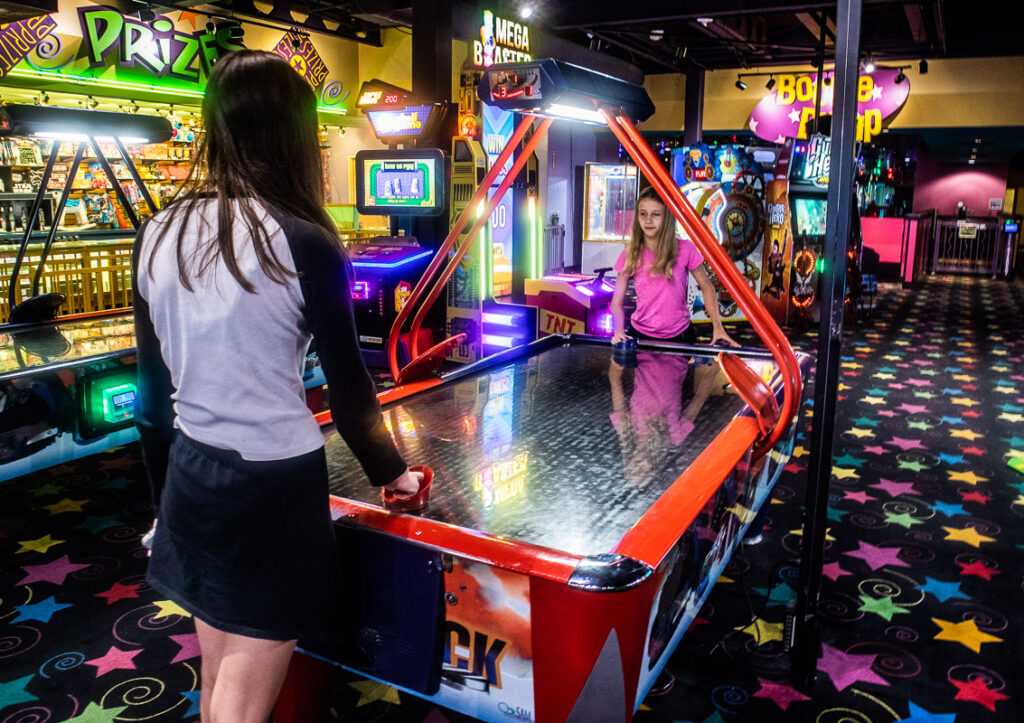 Two girls playing air hockey