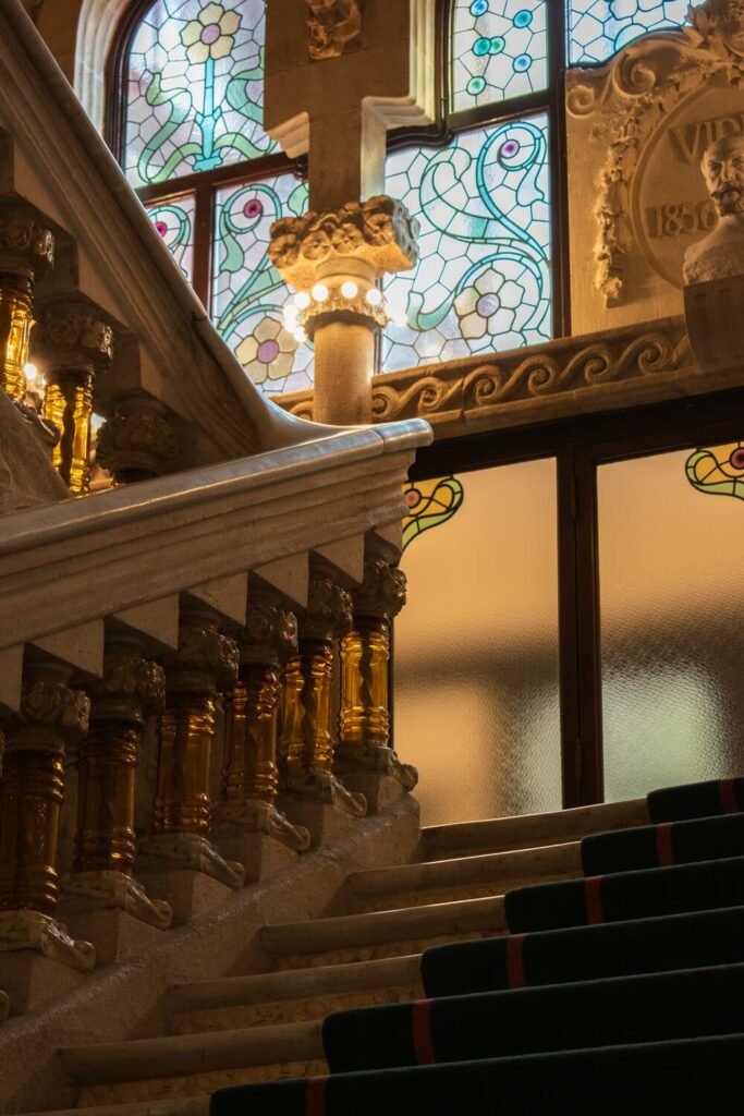 stairs leading up to stained glass window in concert hall