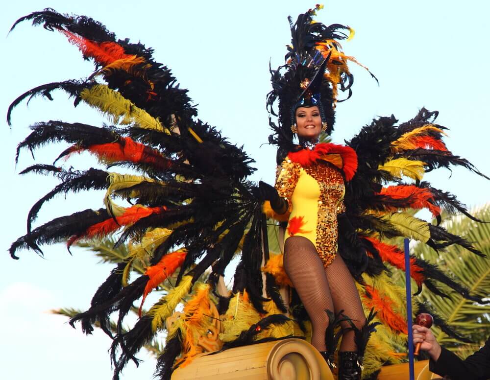 woman in yellow costume with feathered headdress and wings