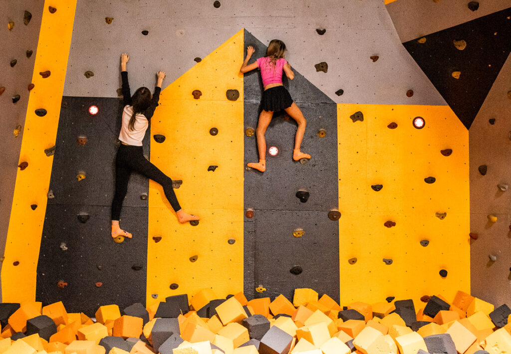 Two teenage girls indoor rock climbing