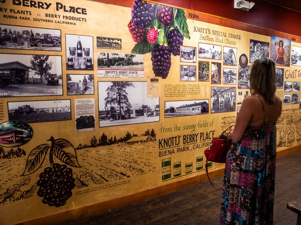 Lady standing in front a large mural sharing the history of Knott’s Berry Farm